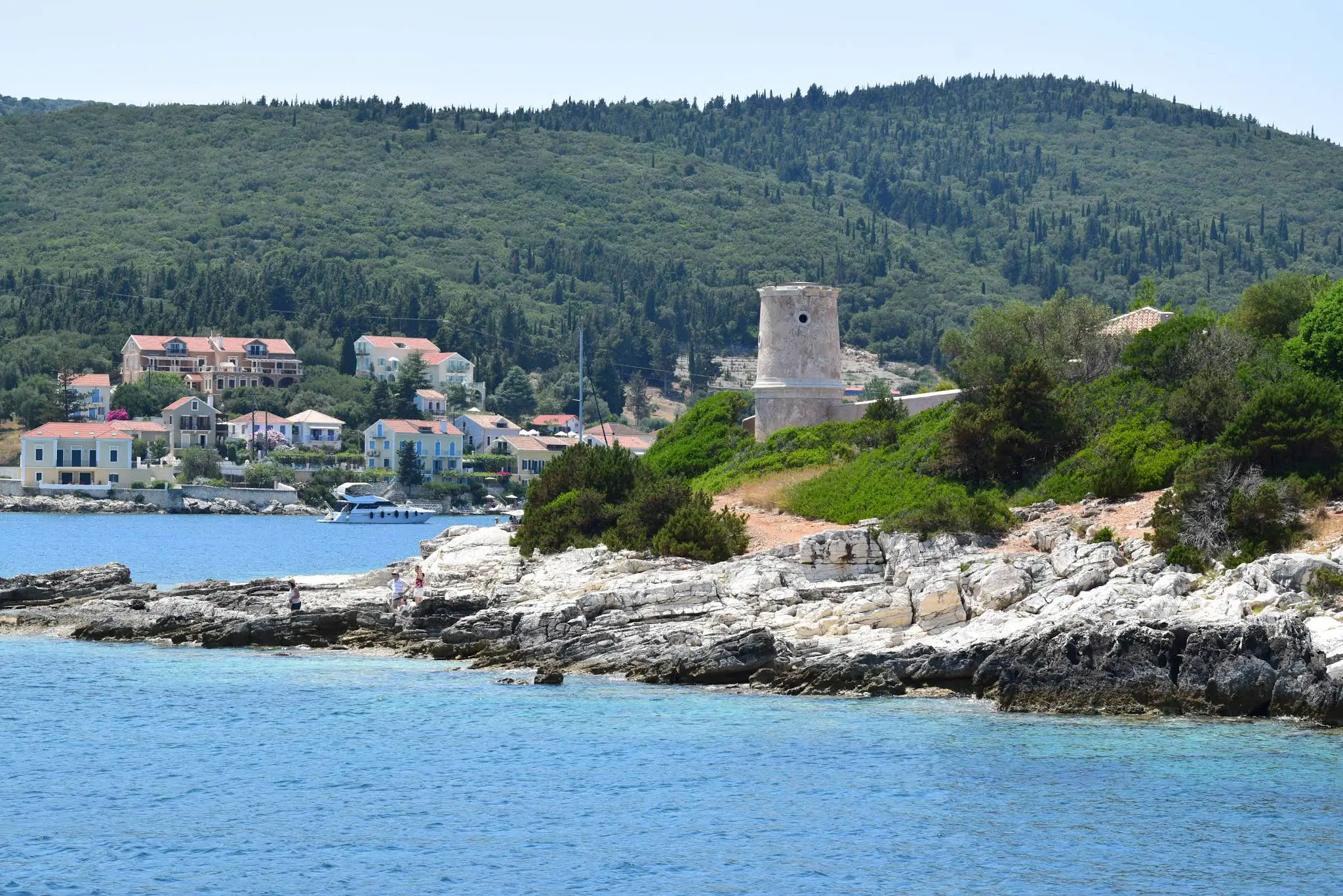Sailing past the historic Venetian Lighthouse into the cosmopolitan port of Fiskardo, a signature arrival moment on our private boat charters