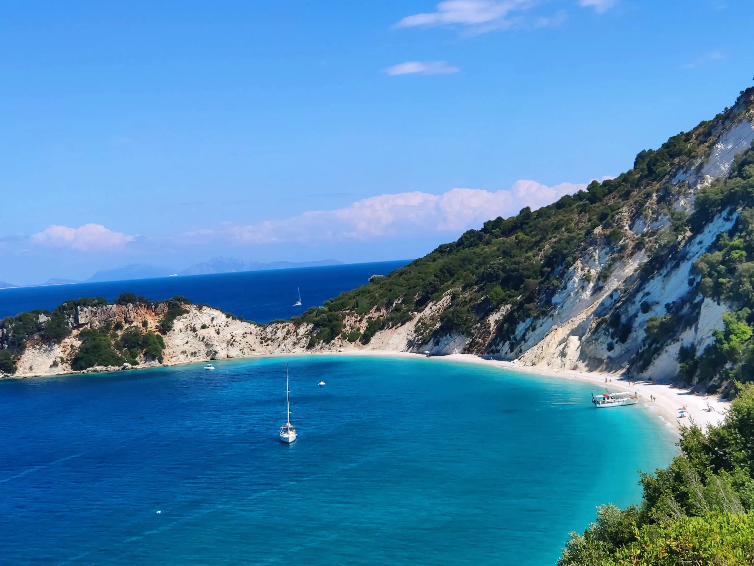 The stunning turquoise waters of Gidaki Beach set against lush green forests, a highlight of our private day cruises to Ithaca