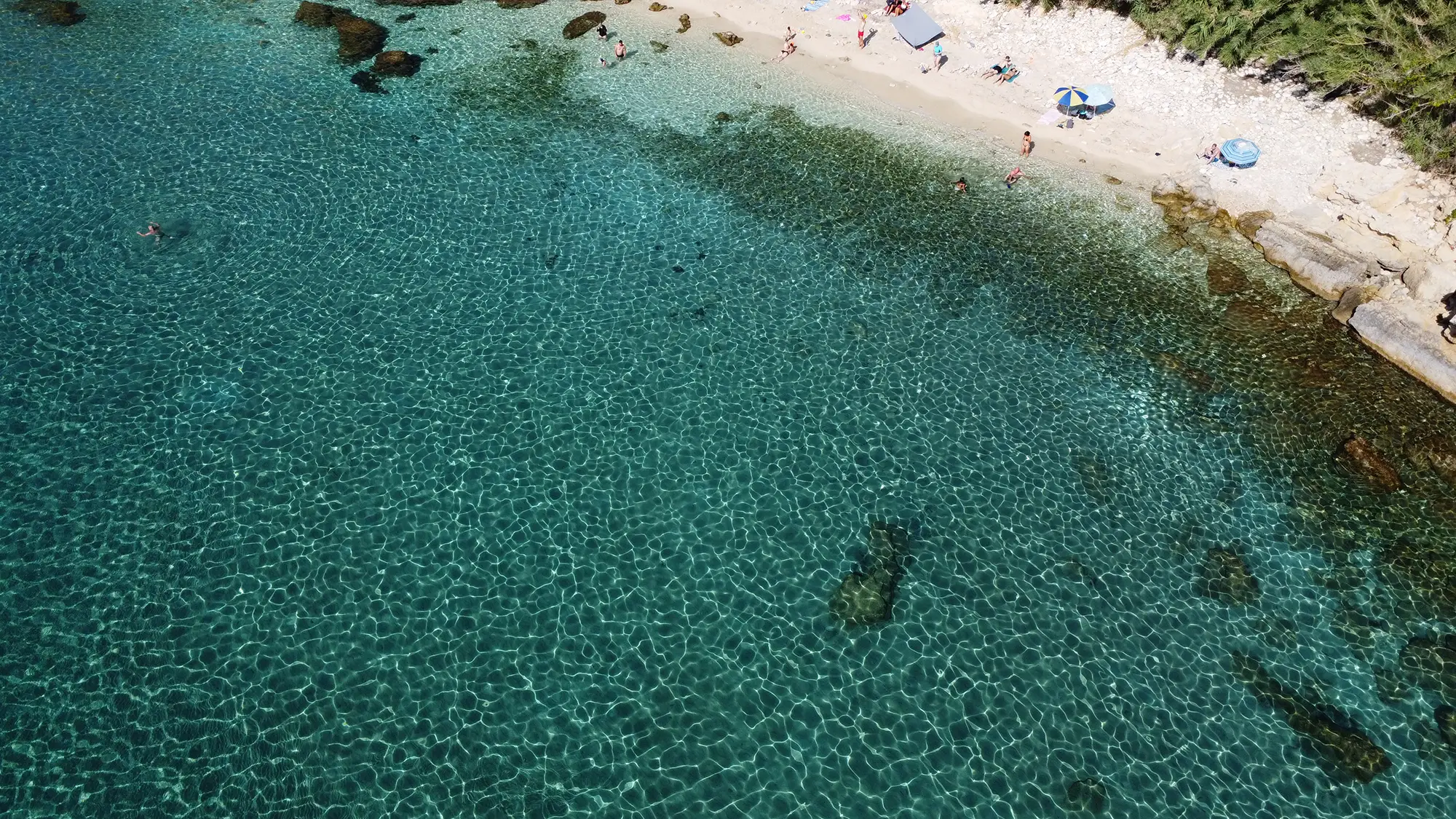 The exotic turquoise coves of Pessada Beach in South Kefalonia, a favorite swimming stop on our private South Coast boat charters